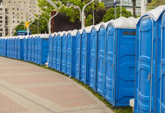 a row of portable restrooms at an outdoor special event, ready for use in Hanson